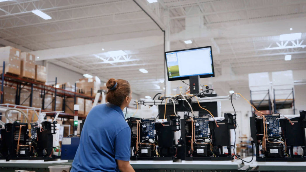 Image showcasing employee working on a computer in warehouse