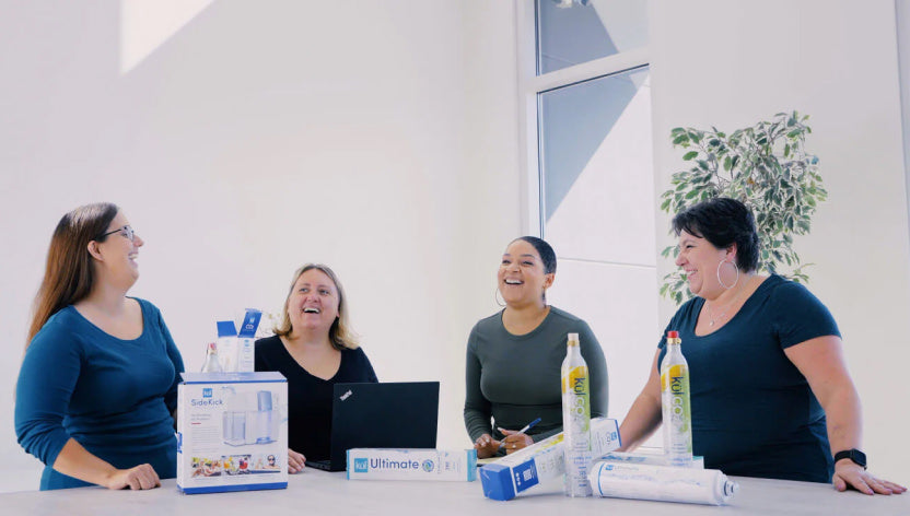 Kul team group photo of 4 women laughing in a professional setting